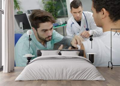 young internist doctor injecting a patient under surveillance Wall mural