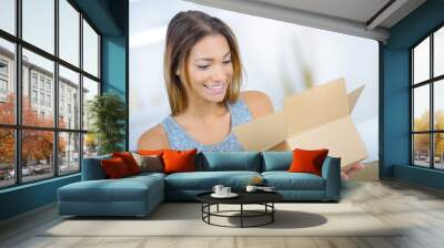 Young lady looking into open cardboard box Wall mural