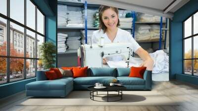 Young lady using sewing machine Wall mural