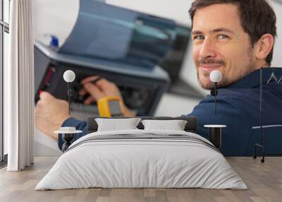 young male technician repairing digital photocopier Wall mural