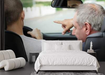 young man talking tp father while driving Wall mural