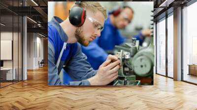 young man with ear protection in factory Wall mural