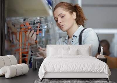 young woman buying tools in hardware store Wall mural