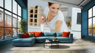 young woman cleans an induction hob Wall mural