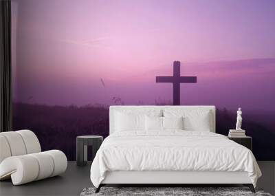 Silhouette of a cross against the soft hues of a dawn sky, creating a peaceful and reverent atmosphere with copy space Wall mural