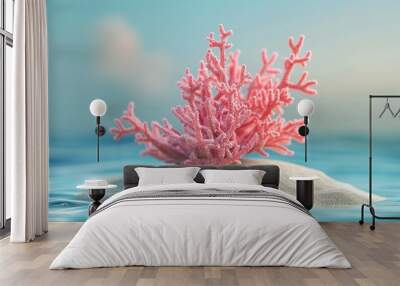 A pink coral plant is on a sandy beach next to the ocean Wall mural