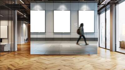 A woman walks past three blank white posters. The posters are in a hallway with a tiled floor Wall mural