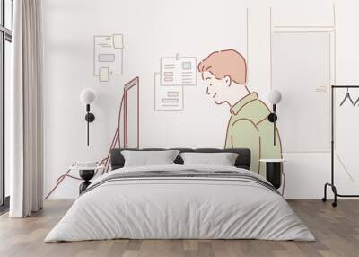 Side view shot of pensive young man sitting at home and working on laptop. Hand drawn style vector design illustrations. Wall mural