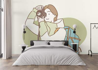 woman with backpack taking a photo. Hand drawn style vector design illustrations. Wall mural