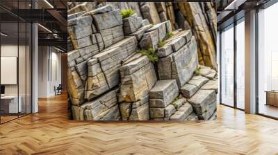 Close-up of a jagged rock formation against a gray background, with cracks and fissures showcasing its geological history. Wall mural