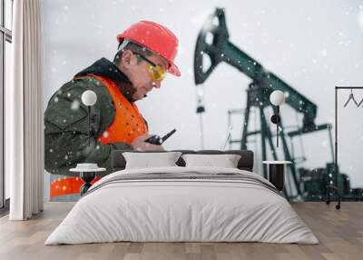 Oil Drill, oil and gas field ,pump jack,  snow storm and worker. Wall mural