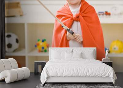 boy wearing paper hat, cape and carrying a sword Wall mural