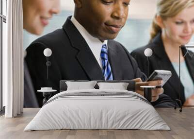 Businessman text messaging on cell phone in conference room Wall mural