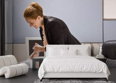 businesswoman changing baby diaper at desk Wall mural