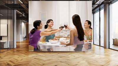 Friends toasting with red wine at dinner party Wall mural