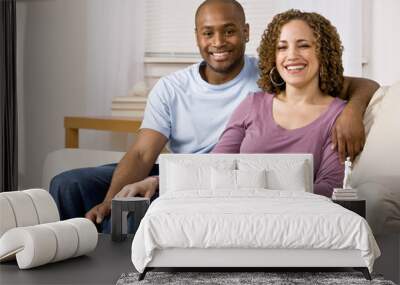 Relaxed couple hugging and sitting on sofa in livingroom Wall mural