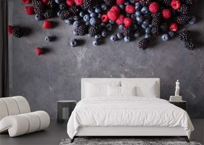 Raspberries, blackberries, blueberries a gray abstract background. Copyspace. Healthy food concept.  Colorful festive still life. Loosely laid berries in different positions Wall mural