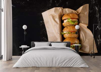 Three burgers on a dark background, in the craft, view from above Wall mural