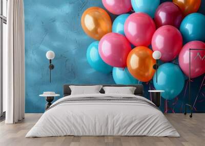 A cluster of balloons in a spectrum of colors serves as a beacon of hope and joy, rising against a serene blue backdrop Wall mural