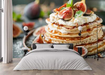 Delicious stacked pancakes topped with fresh figs and mint on a wooden table in sunlight Wall mural