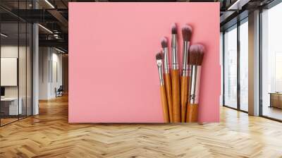 Cosmetic product for makeup. Makeup brushes on a pink background. Creative fashion concept. Collection of cosmetic makeup brushes, top view, banner.Flat lay. Wall mural