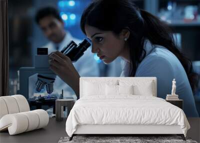 An Indian female scientist uses adult concentration biotechnology under a microscope. Wall mural