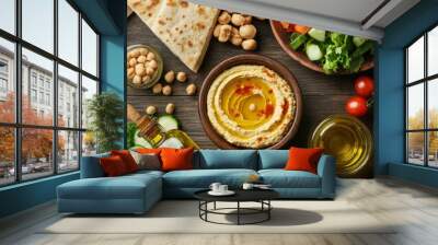 Mediterranean breakfast spread with pita bread, hummus, olives, and a salad of fresh vegetables, served with freshly squeezed juice Wall mural