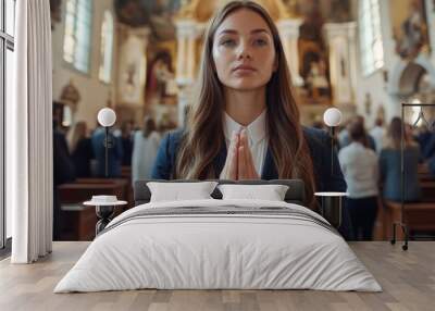 The soft natural light of a church illuminates a woman praying Wall mural