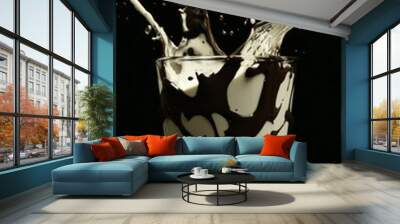 The swirl of milk brown coffee liquid with little bubbles and the falls of coffee beans are isolated Wall mural