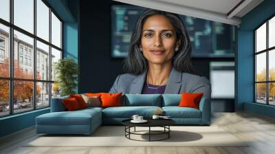 A confident female CEO stands in a modern office, showcasing leadership qualities and success while engaging with her team during a strategic planning session Wall mural