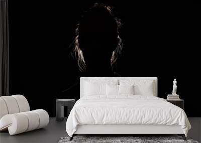 backlit portrait silhouette of unrecognizable woman hiding face and identy in the dark shadow Wall mural