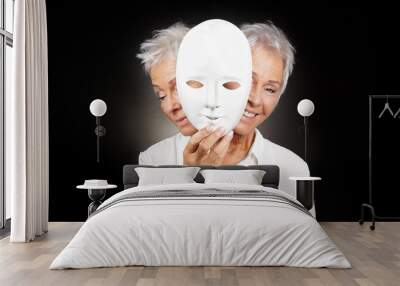 older woman hiding happy and sad face behind mask, concept for manic depression or bipolar or dramedy comedy drama Wall mural