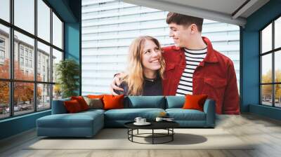 teenage couple in love looking into each others eyes, urban setting with copy space Wall mural