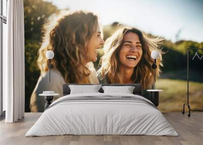 two blond young women laughing and having fun together in nature Wall mural