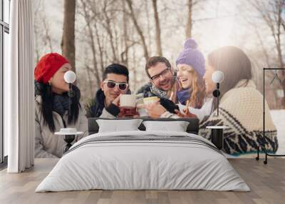 Group of friends enjoying in the snow in winter Wall mural