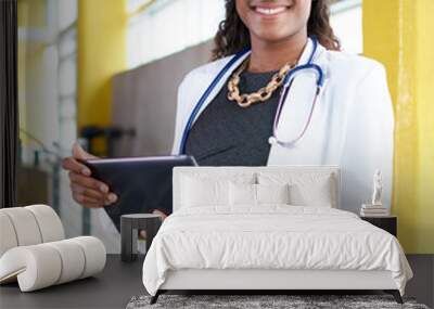 Portrait of a female doctor holding her patient chart on digital tablet in bright modern hospital Wall mural