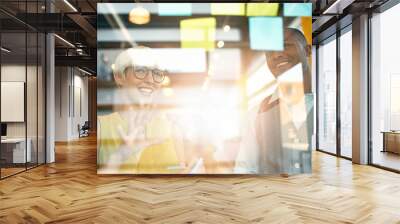 two creative millenial small business owners working on social media strategy brainstorming using ad Wall mural