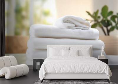 White towels neatly rolled on a white table, ample copy space, blurred living room backdrop Wall mural