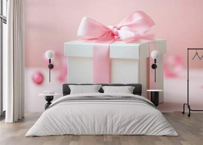 A minimalist backdrop highlights a white gift box adorned with a pink ribbon bow, creating an elegant setting for the gift box and providing ample space for design elements. Wall mural