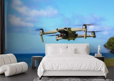 Small high tech drone flying in front of blue sky Wall mural