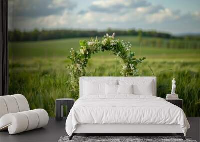 Outdoor photo of 1st may wreath, open on top right side of its perimeter, in front of a green field  Wall mural