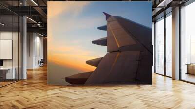 Flying and traveling, view from airplane window on the wing on sunset time Wall mural