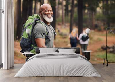 Portrait, black man and hiking in forest, exercise and fitness for wellness, healthy lifestyle and smile. Face, senior male and mature gentleman with backpack, smile and hiker in woods and fresh air Wall mural