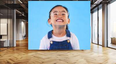 Glasses, student smile and Asian child in portrait in studio isolated on a blue background mockup space. Happy, nerd and face of school kid, girl or geek in casual clothes, fashion and style in Japan Wall mural