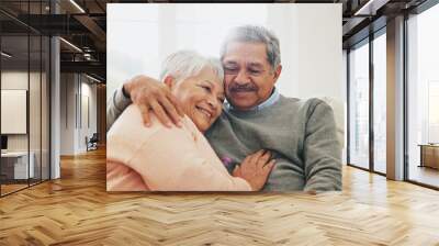 Hug, relax and senior couple in house, love and care with retirement, happiness and bonding together. Apartment, embrace and mature woman with elderly man on sofa, support and comfortable in lounge Wall mural