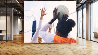 Netball, goal shooter and fitness of a girl athlete group on an outdoor sports court. Aim, sport game and match challenge of a black person with a ball doing exercise and training in a competition Wall mural