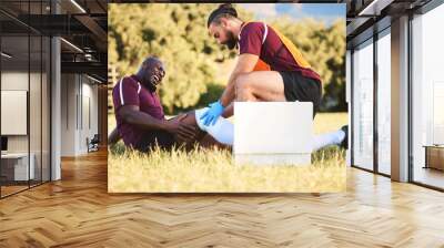 Black man, knee pain and injury, medic help athlete and sports accident on field with health and wellness. Bandage leg, male healthcare worker and support with medical care, inflammation and fracture Wall mural