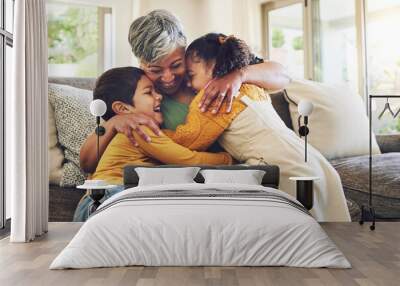 Hug, grandma or happy kids on a sofa with love enjoying quality bonding time together in family home. Smile, affection or senior grandmother relaxing with young children siblings on house couch Wall mural