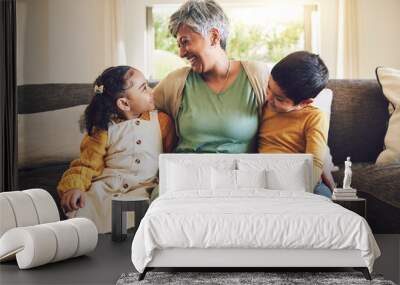 Laughing, grandmother or happy kids on a sofa with love enjoying quality bonding time together in family home. Smile, affection or funny senior grandparent hugging children siblings on house couch Wall mural