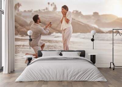 Couple at beach, surprise proposal and engagement with love and commitment with ocean and people outdoor. Travel, seaside and man propose marriage to woman, wow reaction and happiness with care Wall mural